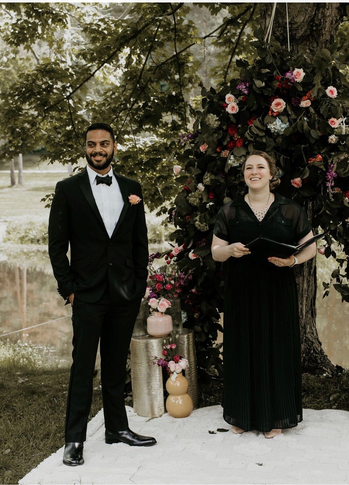 A couple at their floral ceremony arch